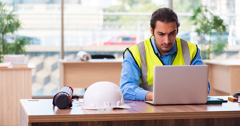 General contractor uses computer at desk