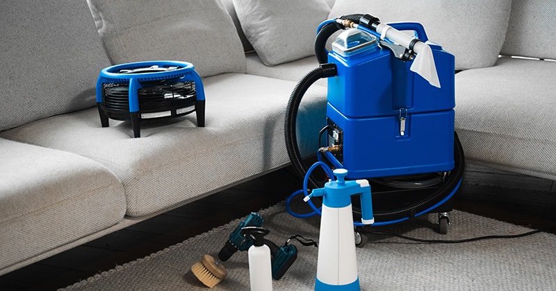 Blue carpet extractor by a couch