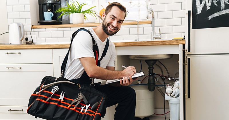 plumbing contractor smiles with clipboard